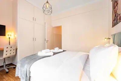 a white bedroom with a bed with towels on it at Acropolis Horizon by WeHost Athens in Athens