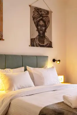 a bedroom with a bed with a statue above it at Acropolis Horizon by WeHost Athens in Athens