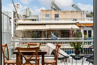 a patio with a table and chairs on a balcony at Acropolis Horizon by WeHost Athens in Athens
