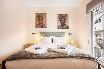a bedroom with a bed with two pictures on the wall at Acropolis Horizon by WeHost Athens in Athens