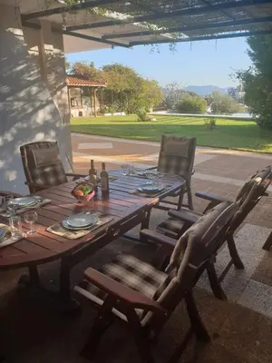 a wooden table with two chairs and a table with food on it at Villa Leonidas in Anavissos