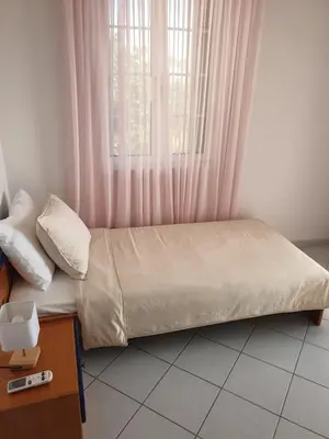 a bed sitting in a room with a window at Villa Leonidas in Anavissos