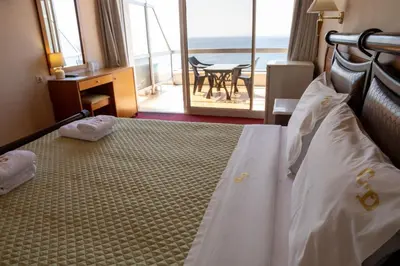 a bedroom with a bed with a view of the ocean at Cavo D' Oro in Piraeus