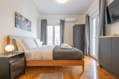 a bedroom with a large bed and a television at Cozy Apartment with Office - 19min to Athens Center in Athens