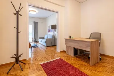 a room with a desk and a chair and a couch at Cozy Apartment with Office - 19min to Athens Center in Athens