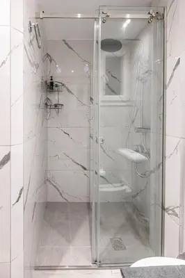 a white bathroom with a shower and a toilet at Cozy Apartment with Office - 19min to Athens Center in Athens