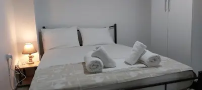 a white bed with white pillows and towels on it at Camellia Apartment ATHENS CENTER 5BD, 2 BATHS in Athens