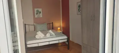 a small bedroom with a bed with towels on it at Rose Apartment Athens Center , 5BD, 2 BATH in Athens