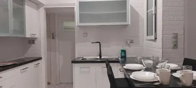 a kitchen with a sink and a table with plates at Rose Apartment Athens Center , 5BD, 2 BATH in Athens