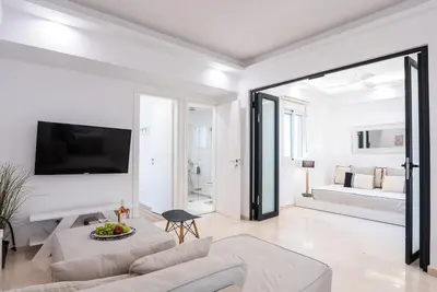 a white living room with a couch and a bed at Athens! Didems Hideaway! in Athens
