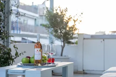 a bottle of wine sitting on a table with wine glasses at Athens! Didems Hideaway! in Athens