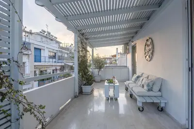 a patio with a couch and a table on a balcony at Athens! Didems Hideaway! in Athens