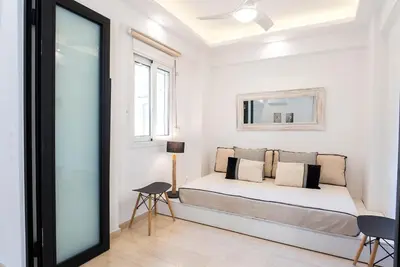 a white bedroom with a bed and a mirror at Athens! Didems Hideaway! in Athens