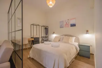 a bedroom with a large white bed and a desk at Exarcheia's Bliss in Athens