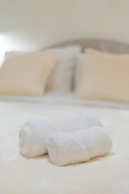a white towel sitting on top of a bed at Exarcheia's Bliss in Athens
