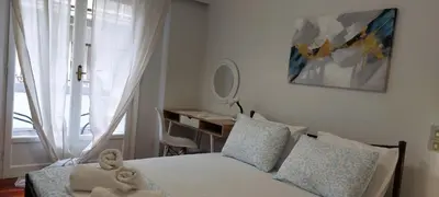 a bedroom with a bed and a desk and a window at Vintage Apartment Athens Center 6BD-2BATH in Athens