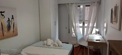 a bedroom with a bed and a desk and a window at Vintage Apartment Athens Center 6BD-2BATH in Athens