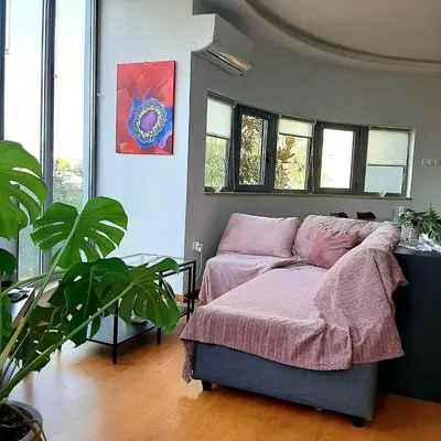 a bedroom with a bed in a room with windows at Andromeda-The Airport Home in Markopoulo