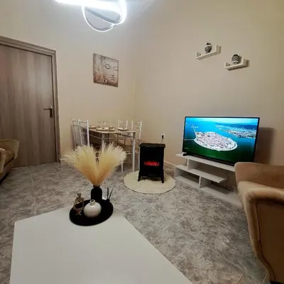 a living room with a flat screen tv and a fireplace at Central Piraeus port apartment in Piraeus