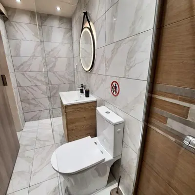 a bathroom with a toilet and a sink and a mirror at Central Piraeus port apartment in Piraeus