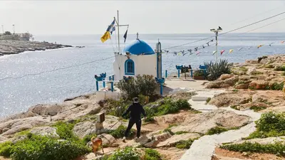 a man walking a dog next to a lighthouse at Central Piraeus port apartment in Piraeus