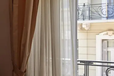 a curtain in front of a window with a balcony at Marvelous apartment in Plaka in Athens