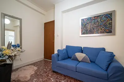 a blue couch in a living room with a painting at Piraiki Sea View Apt, 2bdrms, 4 pers by MPS in Piraeus