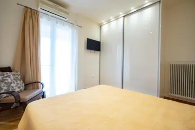 a bedroom with a bed and a chair and a window at Piraiki Sea View Apt, 2bdrms, 4 pers by MPS in Piraeus