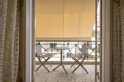 a table and chairs sitting on a balcony at Piraiki Sea View Apt, 2bdrms, 4 pers by MPS in Piraeus
