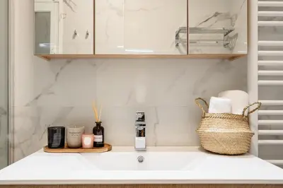 a bathroom counter with a sink and a basket on it at Stylish 1BD Apt in Elliniko in Athens