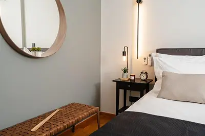 a bedroom with a bed with a mirror and a table at Stylish 1BD Apt in Elliniko in Athens