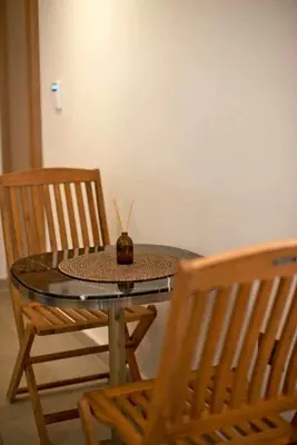 a glass table with two chairs and a candle on it at Asteria studio in Glyfada in Athens