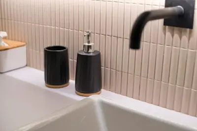 a bathroom sink with two soap dispensers on a counter at Asteria studio in Glyfada in Athens