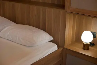 a bed with a white pillow next to a lamp at Asteria studio in Glyfada in Athens