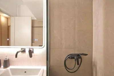 a bathroom with a shower with a sink and a mirror at Asteria studio in Glyfada in Athens