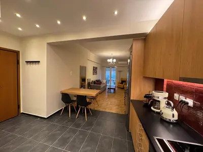 a kitchen and living room with a table and a counter at Nelly's Athens Apartments in Athens