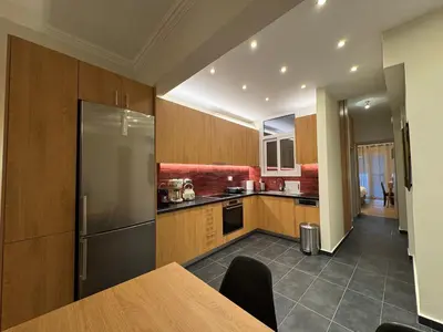a kitchen with a table and a refrigerator at Nelly's Athens Apartments in Athens