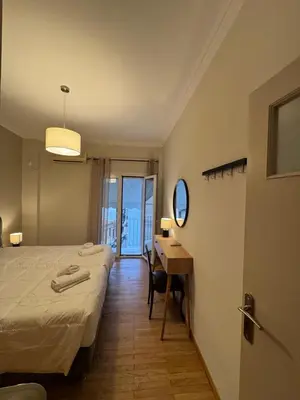 a bedroom with a bed and a desk with a mirror at Nelly's Athens Apartments in Athens