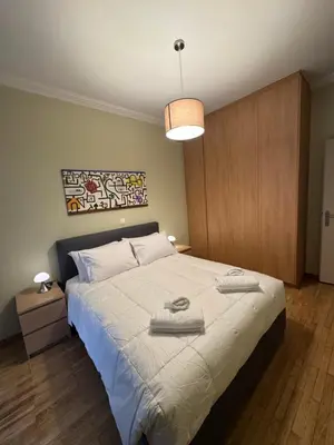 a bedroom with a large bed with towels on it at Nelly's Athens Apartments in Athens