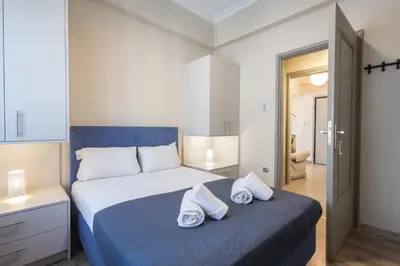 a bedroom with a bed with towels on it at Kastella Waves Chic 2-Bedroom Getaway in Piraeus