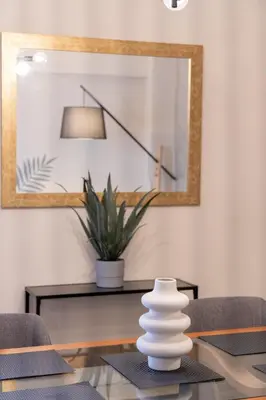a dining room with a mirror and a table with chairs at Kastella Waves Chic 2-Bedroom Getaway in Piraeus
