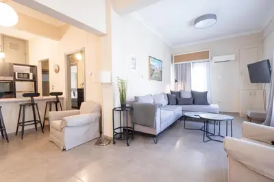 a living room with a couch and a table at Kastella Waves Chic 2-Bedroom Getaway in Piraeus