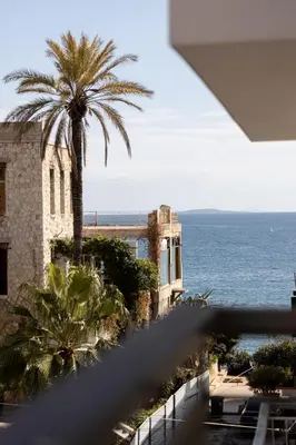 a view of the ocean from a building with a palm tree at Kastella Waves Chic 2-Bedroom Getaway in Piraeus