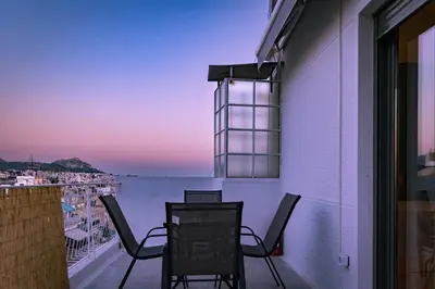 a balcony with chairs and a view of the water at Cosy Penthhouse with stunning view in Athens