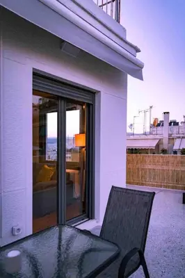 a black chair sitting on the balcony of a house at Cosy Penthhouse with stunning view in Athens