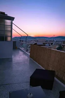 a view of a sunset from the roof of a building at Cosy Penthhouse with stunning view in Athens