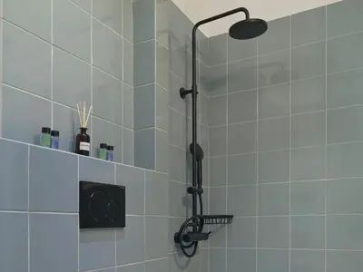 a shower with a black shower head in a bathroom at Amanita Athens Iridanou apartment in Athens