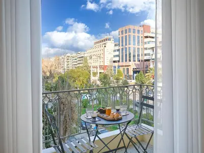 a table with a plate of food on a balcony at Amanita Athens Iridanou apartment in Athens