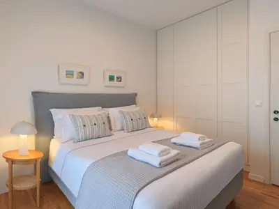 a white bedroom with a bed with towels on it at Amanita Athens Iridanou apartment in Athens