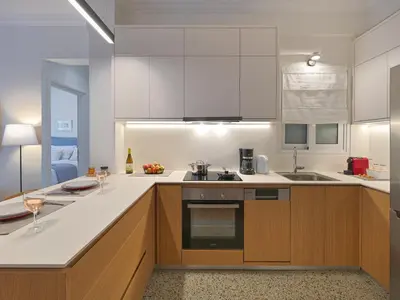 a kitchen with white counters and wooden cabinets at Amanita Athens Iridanou apartment in Athens
